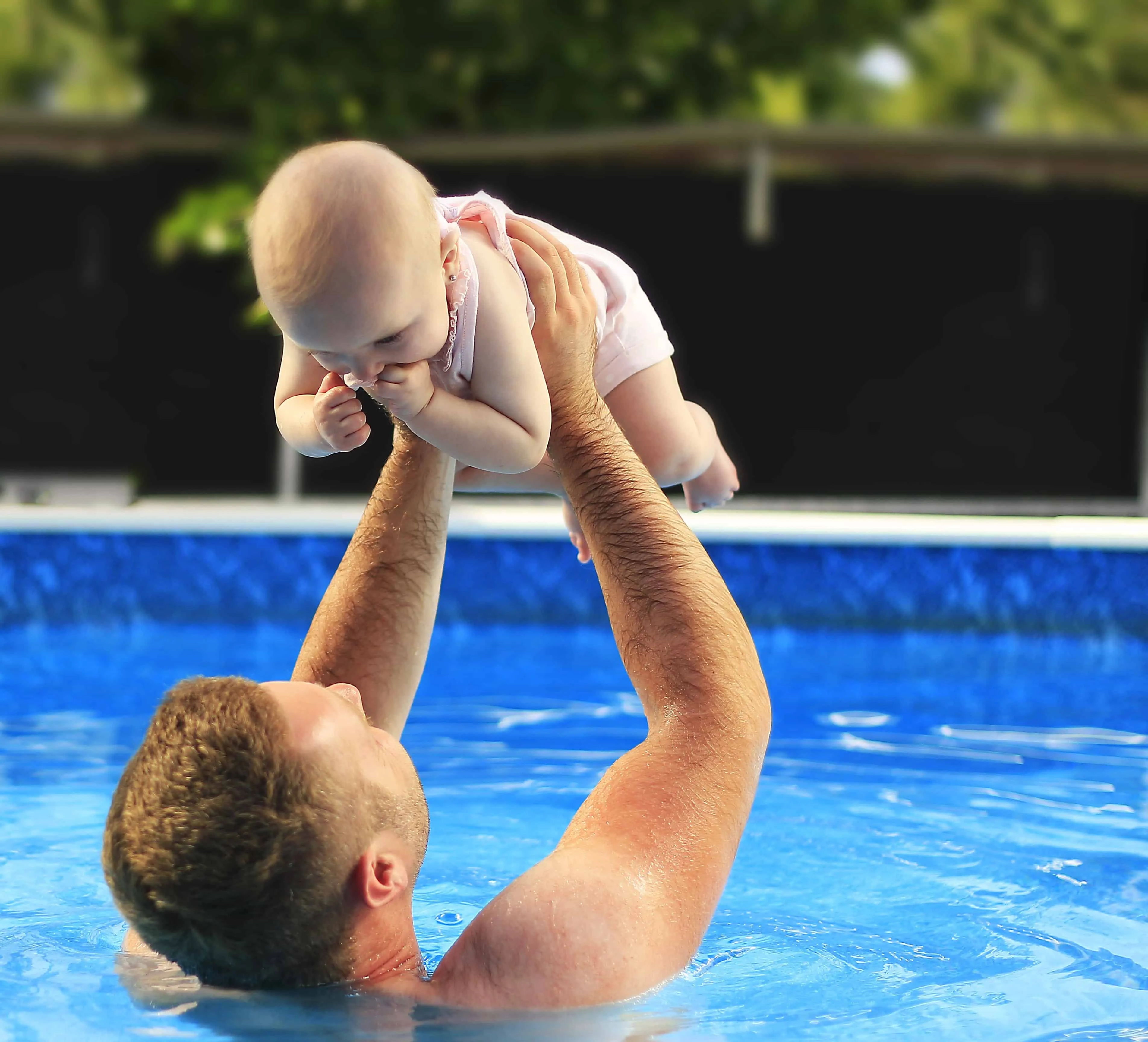 Parent holding a baby in the swimming pool
