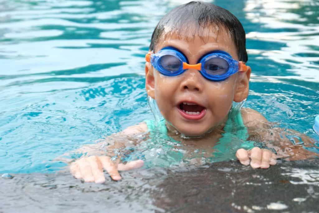 kid with goggles in the swimming pool