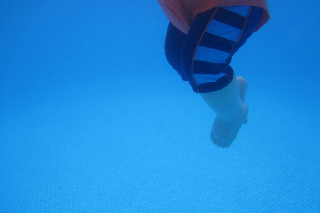baby kicking under water in swimming pool