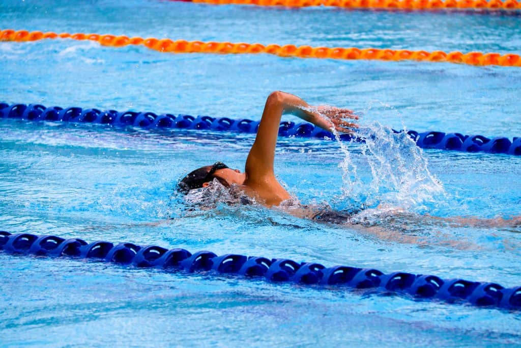 man swimming in olympic swimming pool